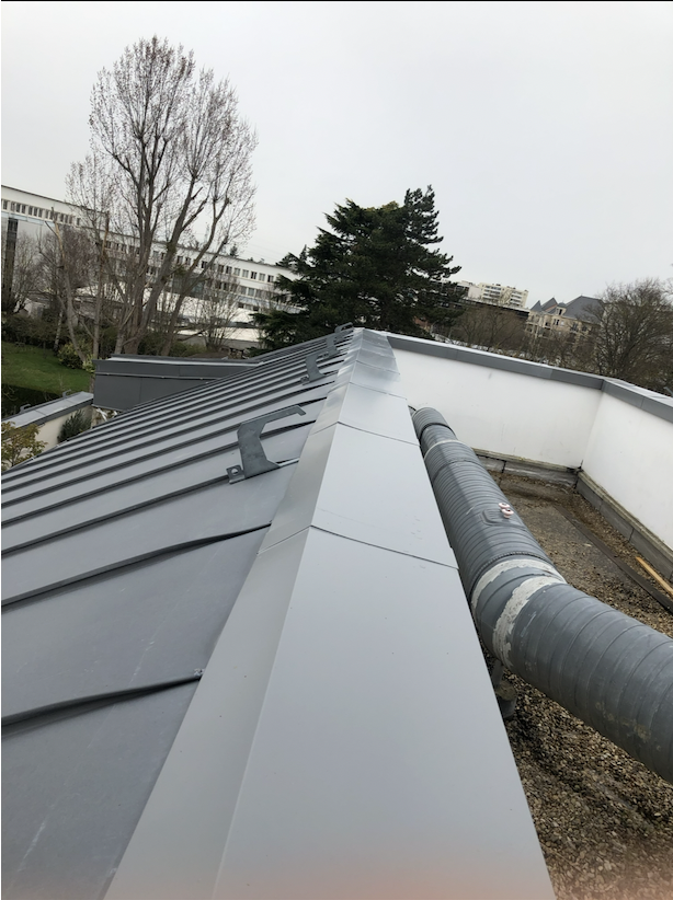 Couverture zinc à joint debout terminée avec habillage de rive et couronnement d'acrotère