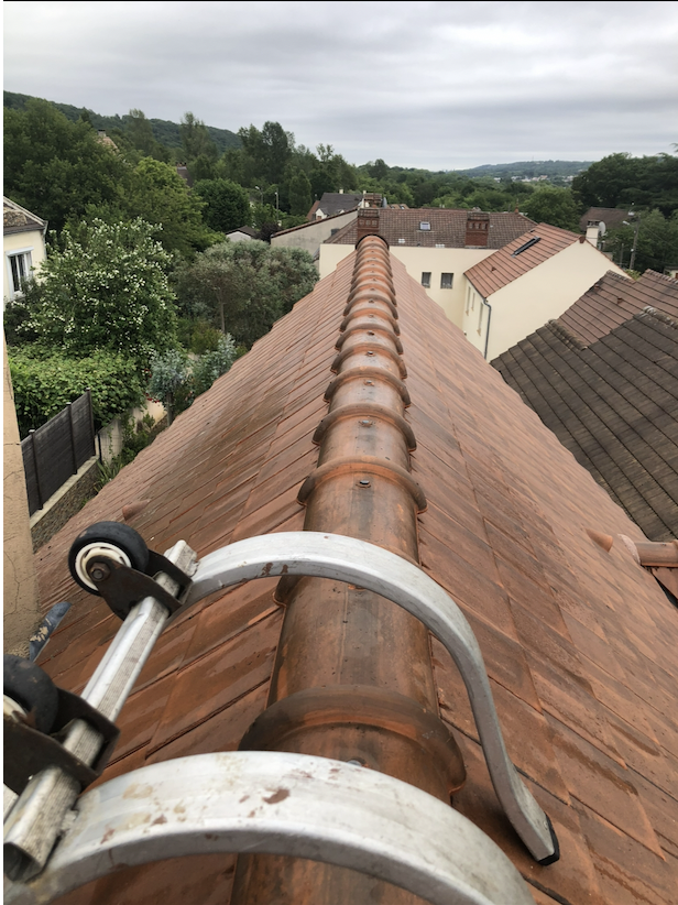 Faîtage en tuiles rondes scellées sur une toiture rénovée