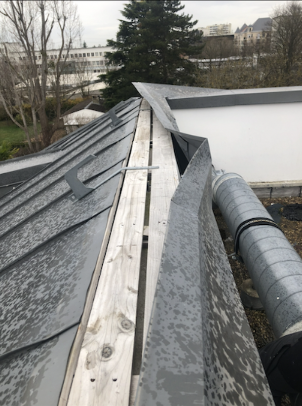 Chantier de couverture zinc à joint debout en cours, voliges et bandes de rive apparentes