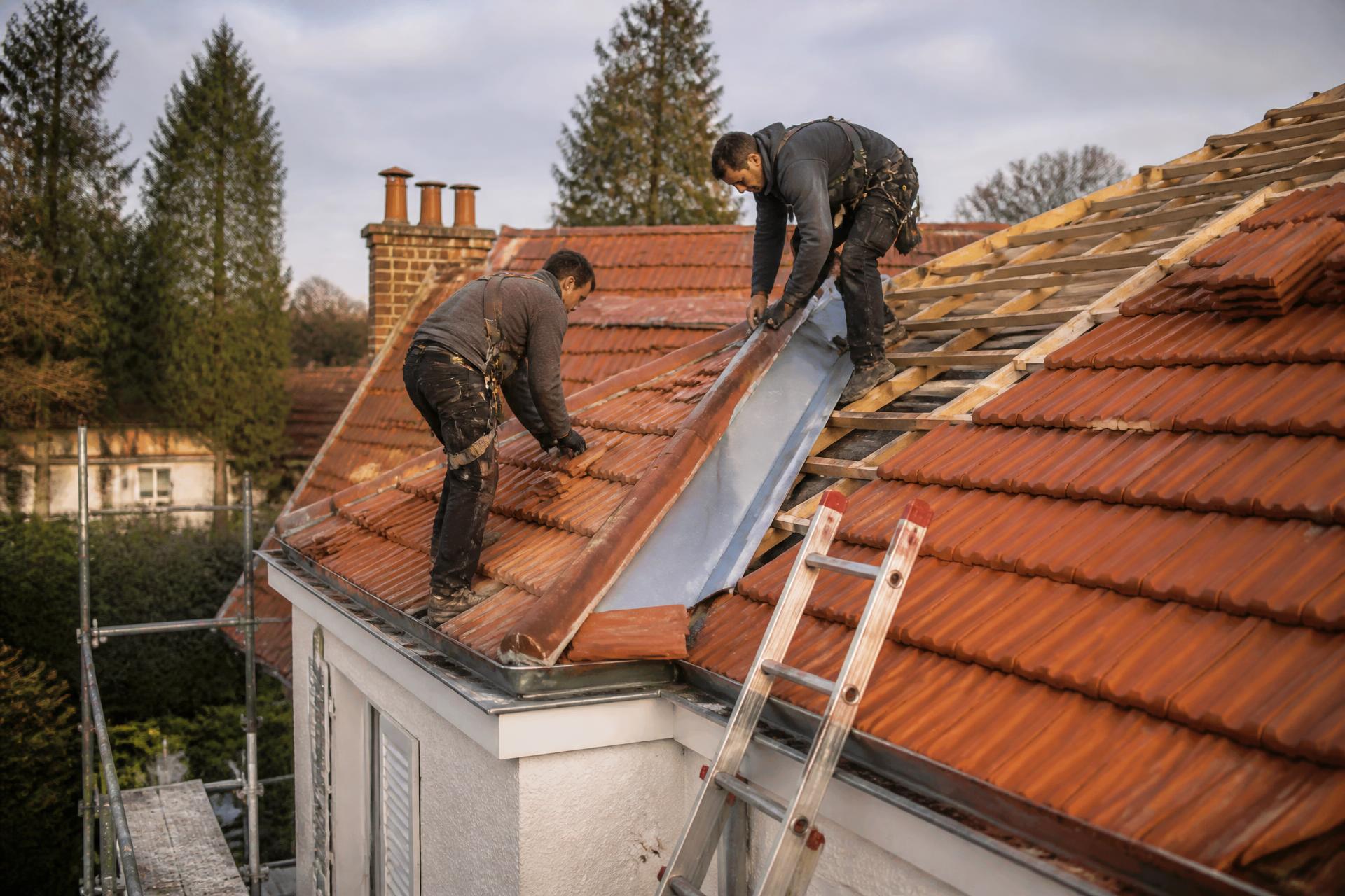 Couvreurs Home Toiture posant des tuiles sur une toiture en Essonne
